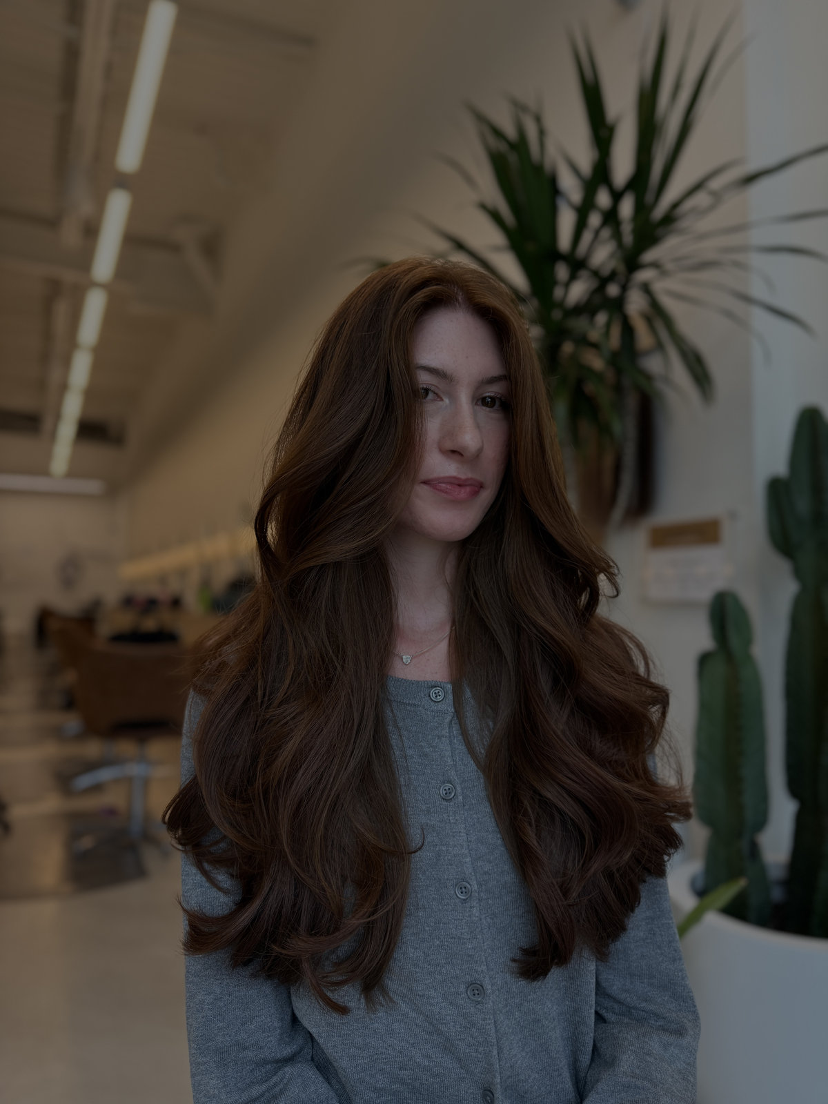 Long glossy auburn waves cascading past chest