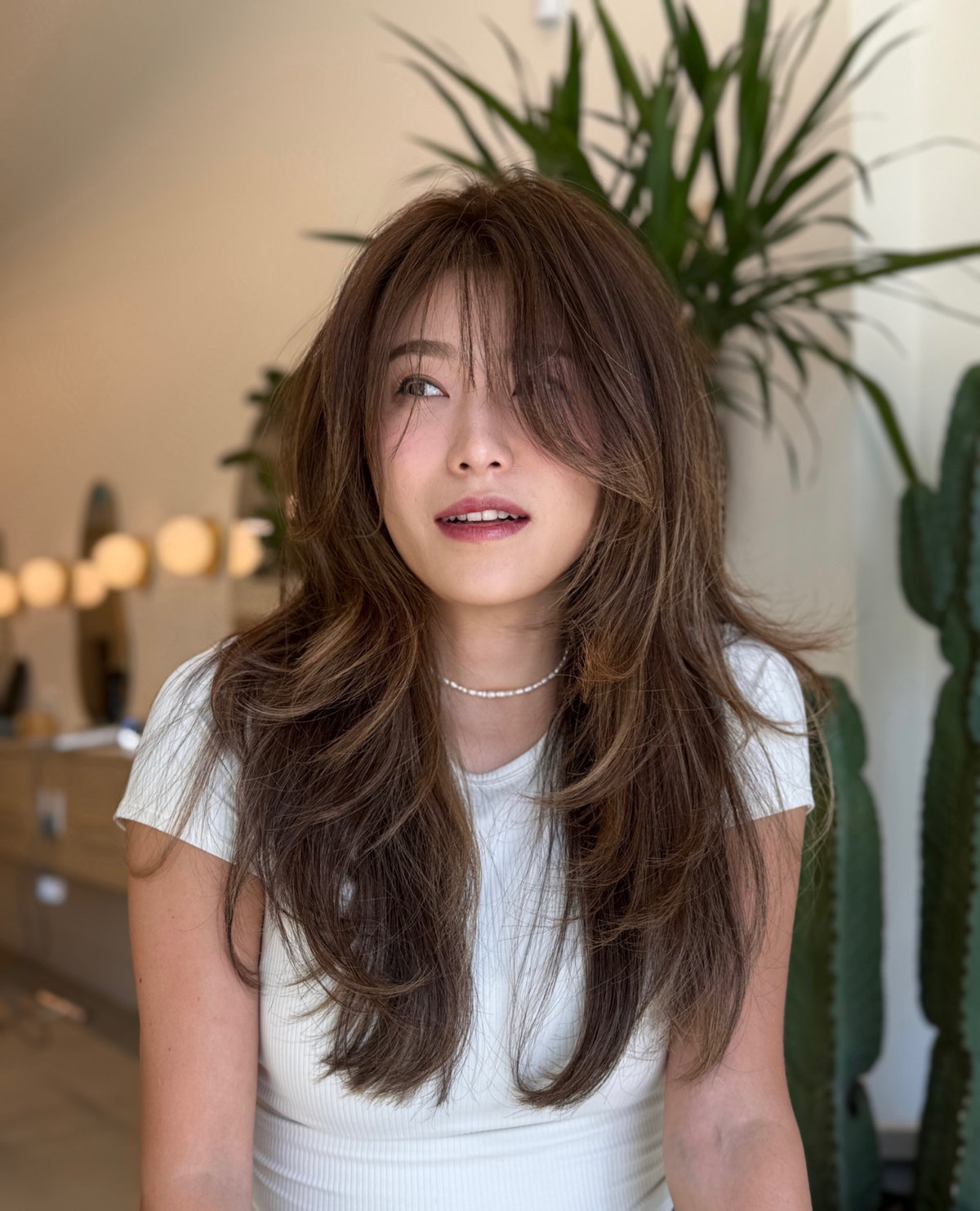 Editorial portrait — layered chestnut hair with curtain fringe