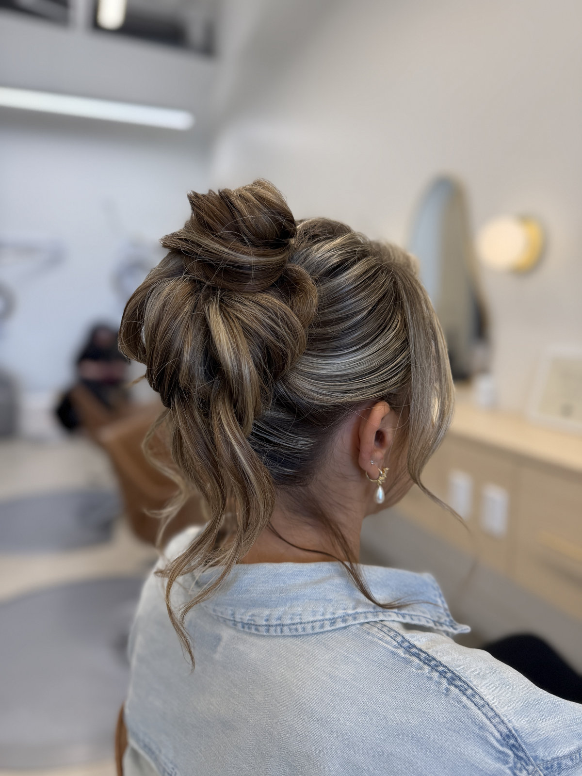 Messy sculptural updo with ash blonde tendrils